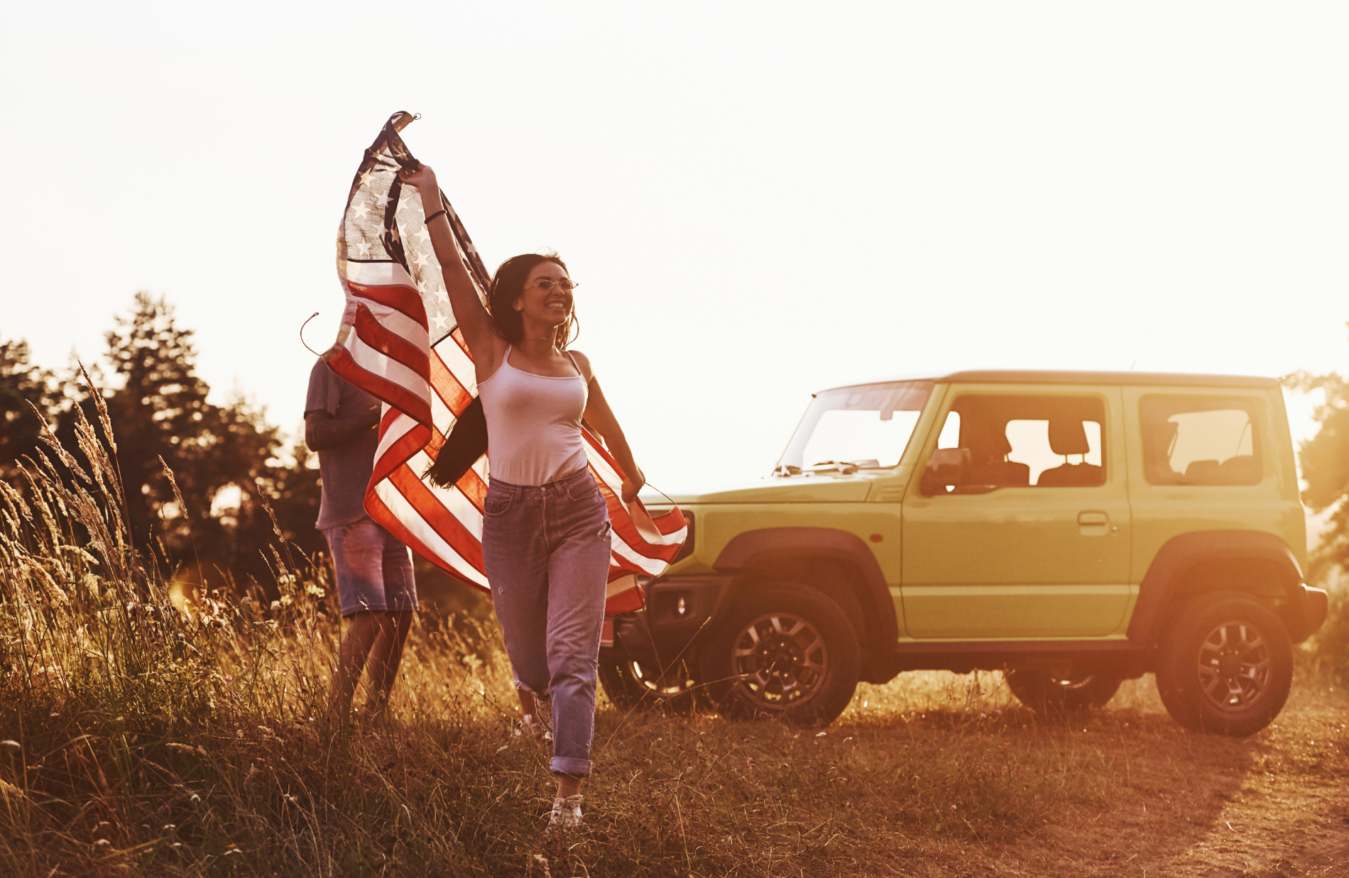 Drivers with US flag by the car